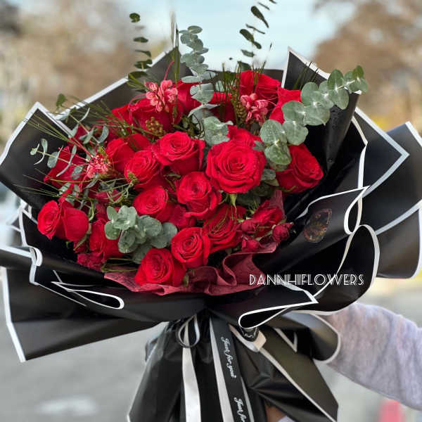 Bouquet of red roses with eucalyptus in black wrapping