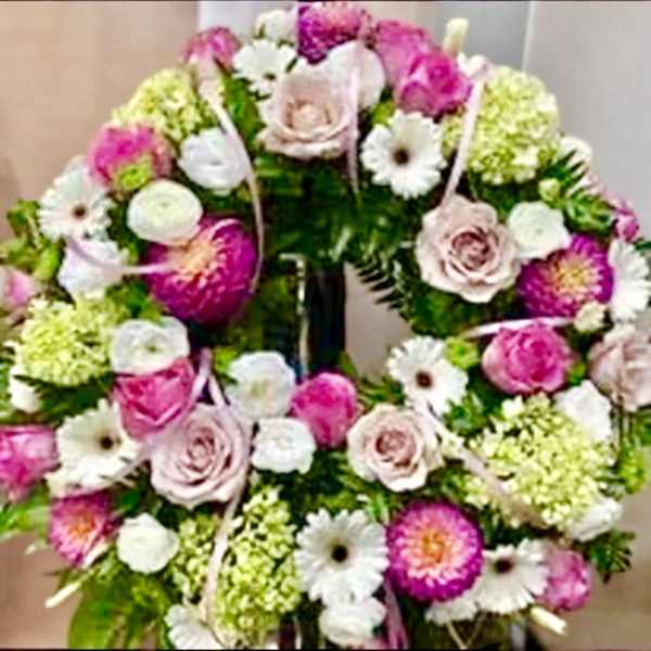 Pink and white floral wreath with roses and daisy-like blooms