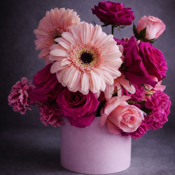 Pink and magenta roses with pale pink gerbera daisies in a blush vase