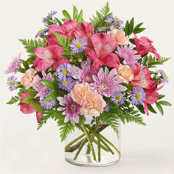 Mixed pink and purple flowers in a clear glass vase