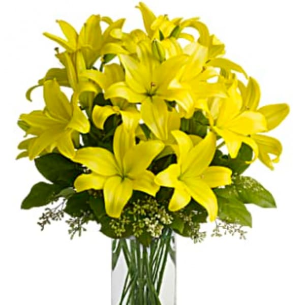 Yellow lilies arranged in a clear glass vase