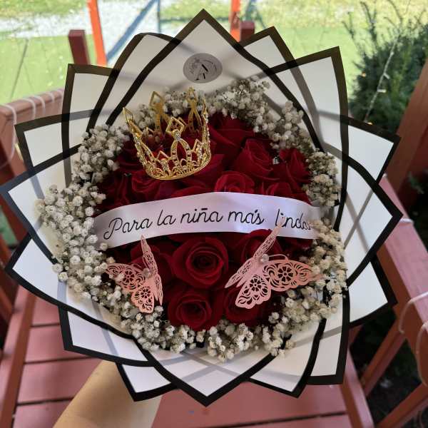Red roses arranged with baby's breath in a decorative bouquet wrap