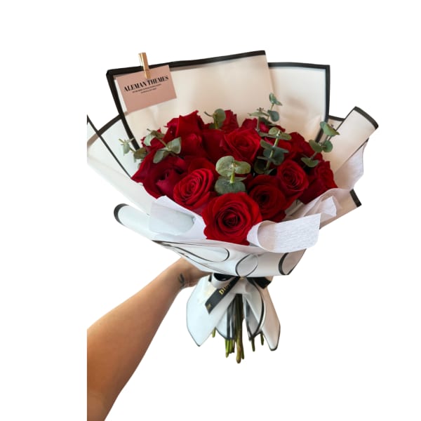 Bouquet of red roses wrapped in white paper with black trim