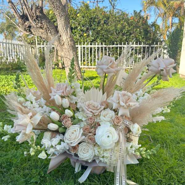 Large bouquet of pale roses and white flowers with pampas grass