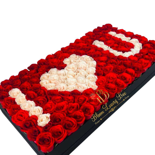 Rectangular box filled with red and white roses arranged in a heart design