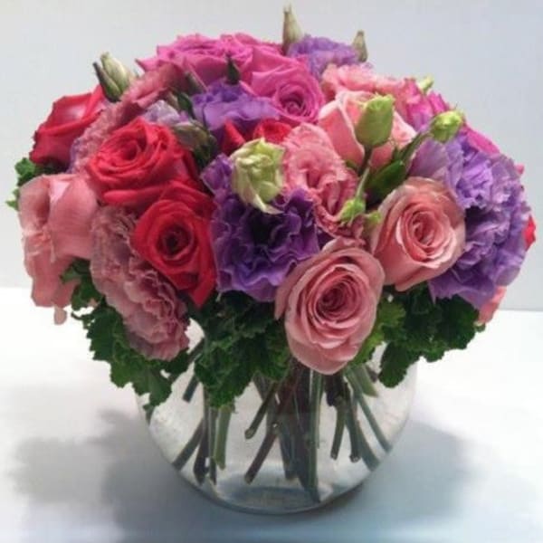 Bouquet of pink and purple roses in a clear glass vase