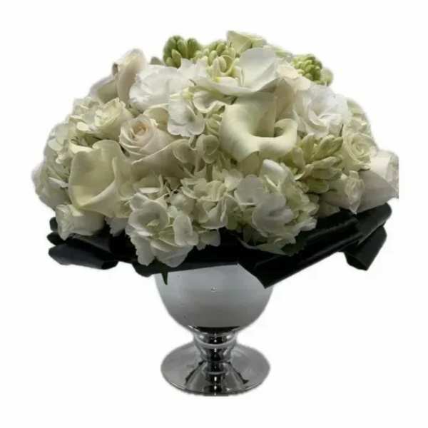 White floral arrangement in a silver pedestal vase