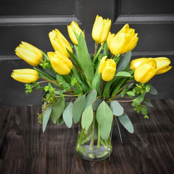 Yellow tulips arranged in a clear glass vase