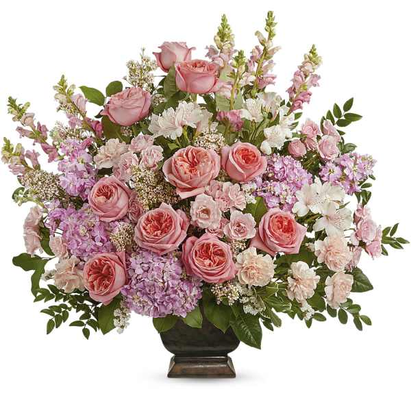Pink roses and mixed blooms arranged in a dark vase