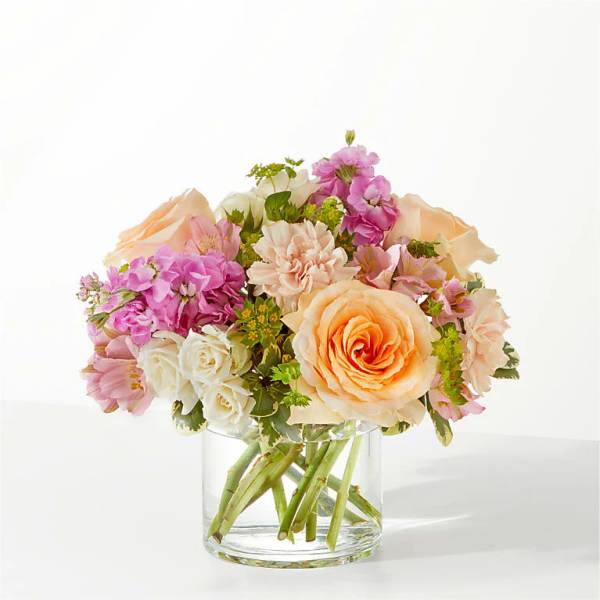 Bouquet of peach, pink, and white flowers in a clear glass vase