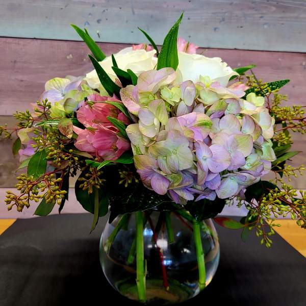 Bouquet of pastel hydrangeas and pink flowers in a glass vase