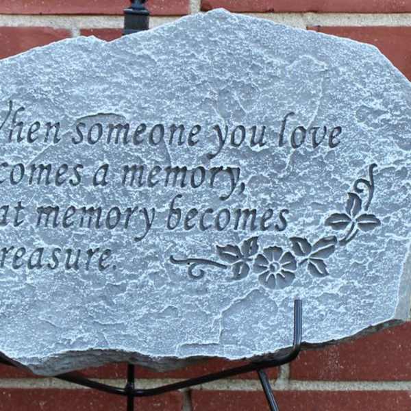 Engraved memorial stone with a sympathy quote on a stand