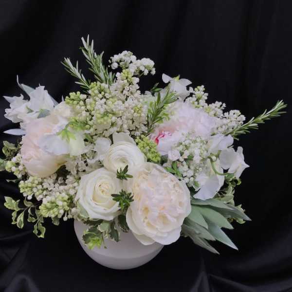 White floral arrangement in a round white vase