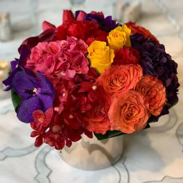 Colorful bouquet of roses and hydrangeas in a white vase
