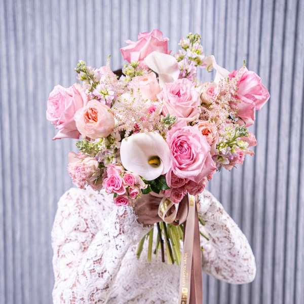 Pink rose and calla lily bouquet with ribbon accents