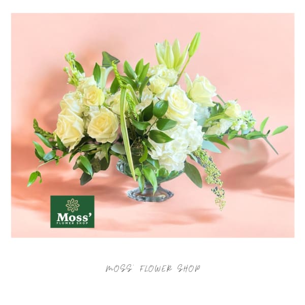 White roses and lilies arranged in a glass vase