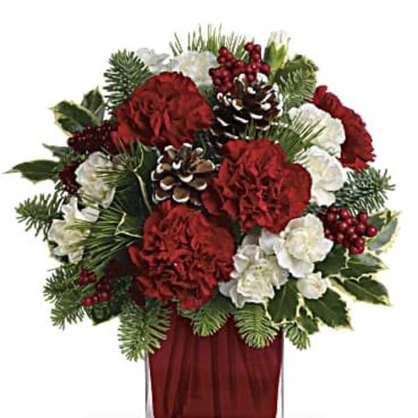 Red and white floral arrangement in a clear square vase