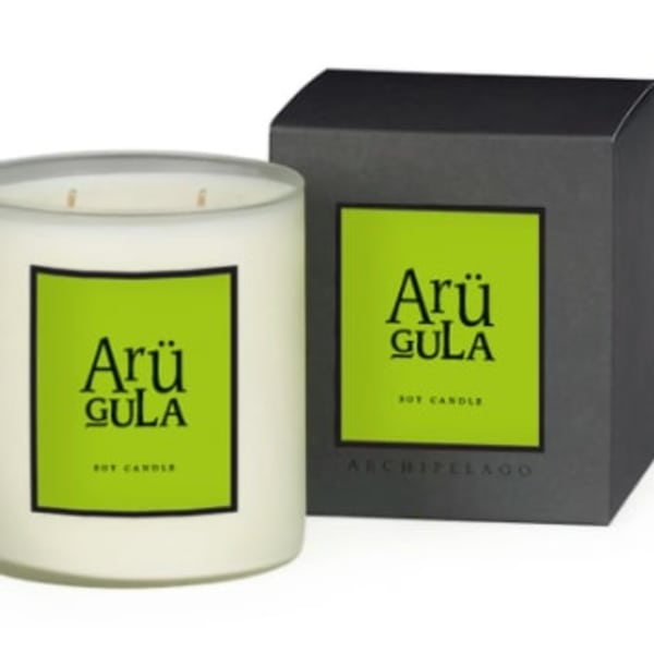 White jar candle with a black box behind it
