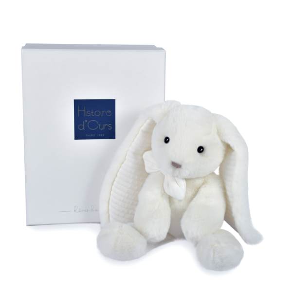 White plush bunny with a ribbon bow beside a branded gift box
