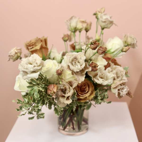 Cream and tan roses arranged in a clear glass vase