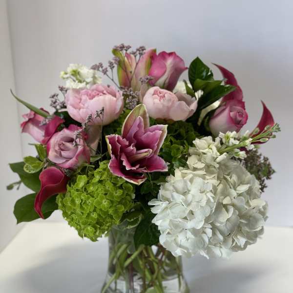 Pink and white floral arrangement in a clear glass vase