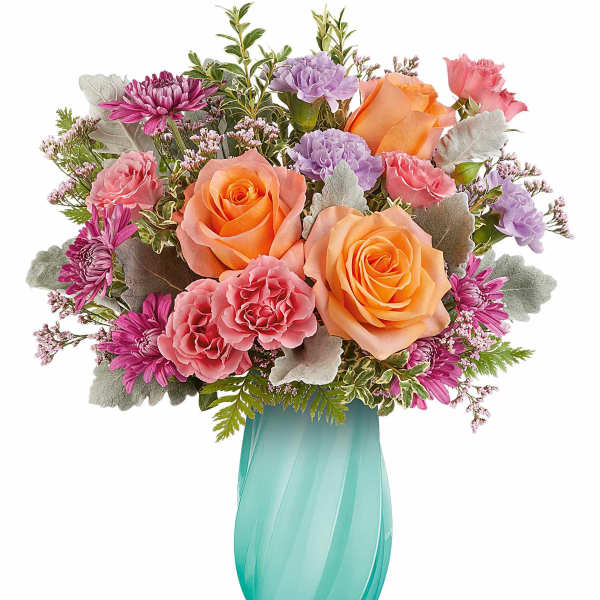 Bouquet of orange and pink roses with purple carnations in a turquoise vase