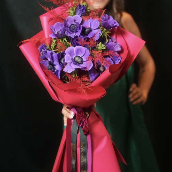 Purple flowers wrapped in bright pink paper and ribbon