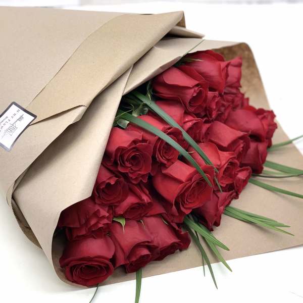 Bouquet of red roses wrapped in brown paper