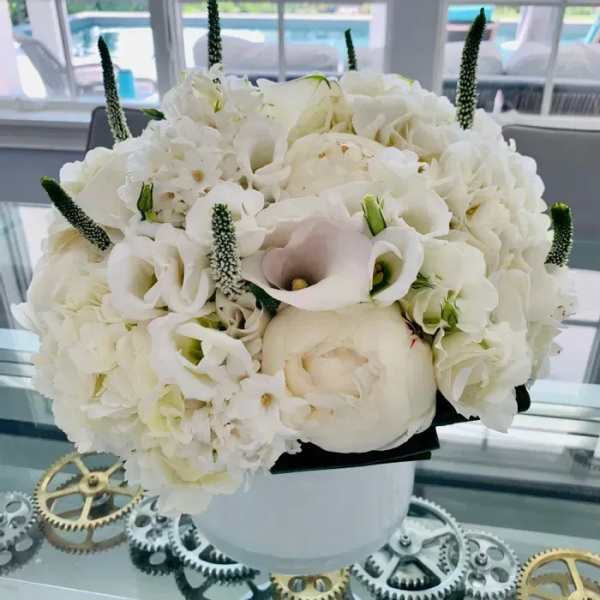White floral bouquet with calla lilies and hydrangeas in a white vase