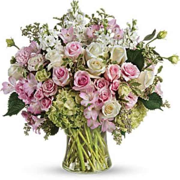 Pink and white roses arranged in a clear glass vase