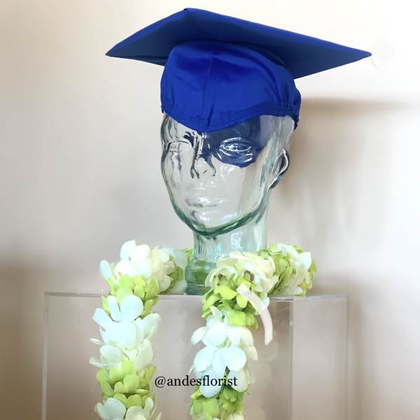 Glass bust wearing a blue graduation cap and a white-green flower lei
