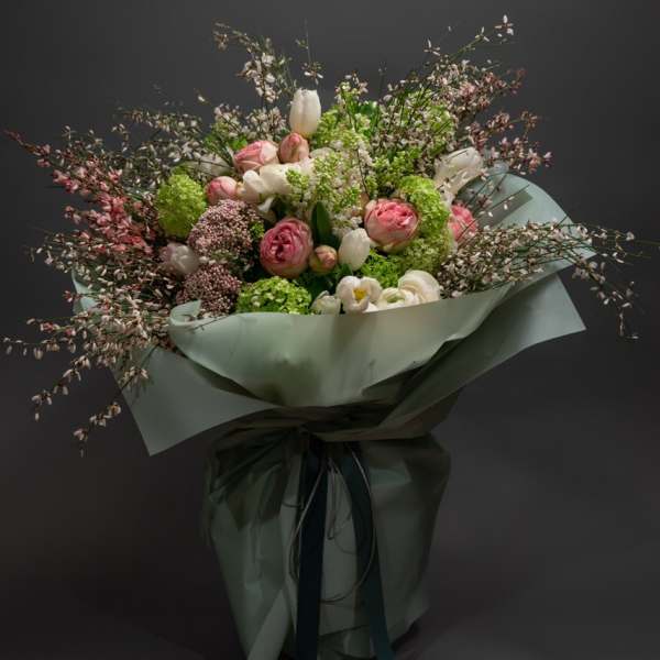Bouquet of pink and white flowers wrapped in pale green paper