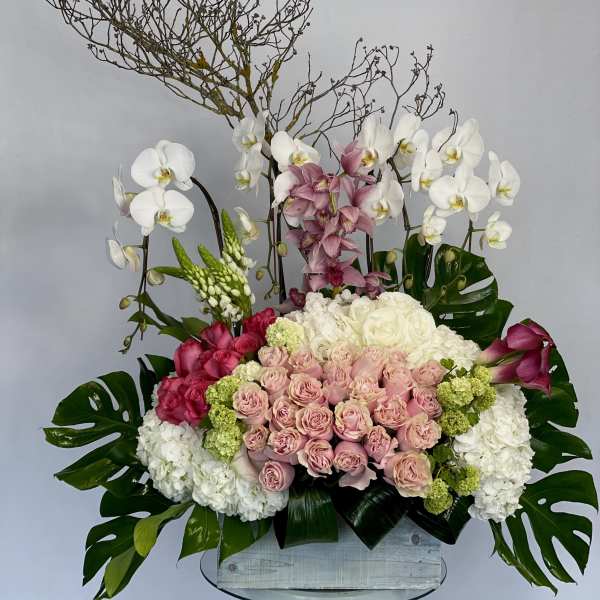 Large floral arrangement with orchids, roses, hydrangeas, and calla lilies in a box