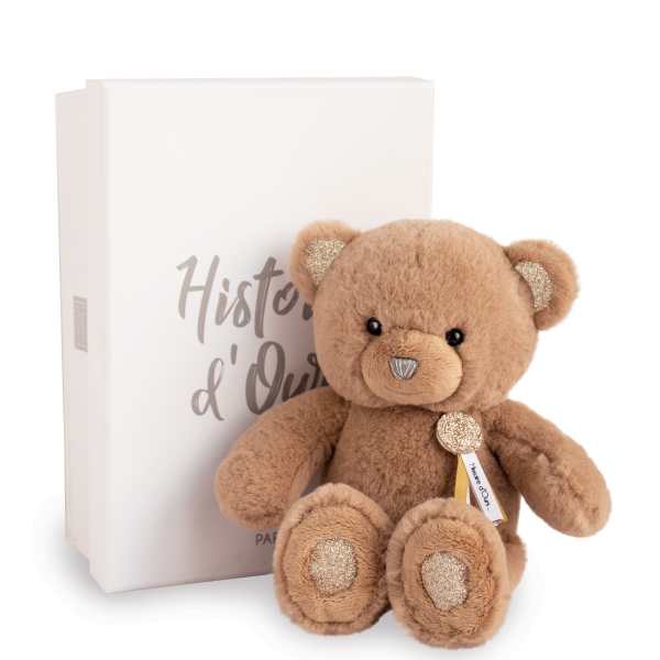Plush teddy bear sitting beside a white gift box