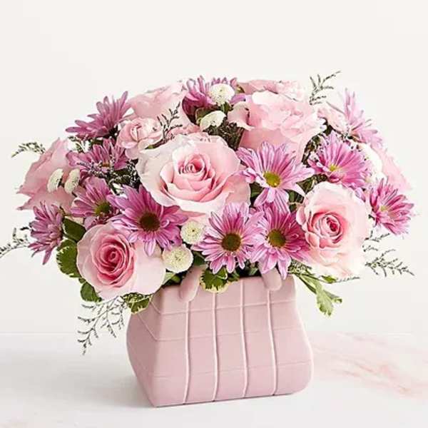 Pink roses and daisy-like flowers in a pink gift box