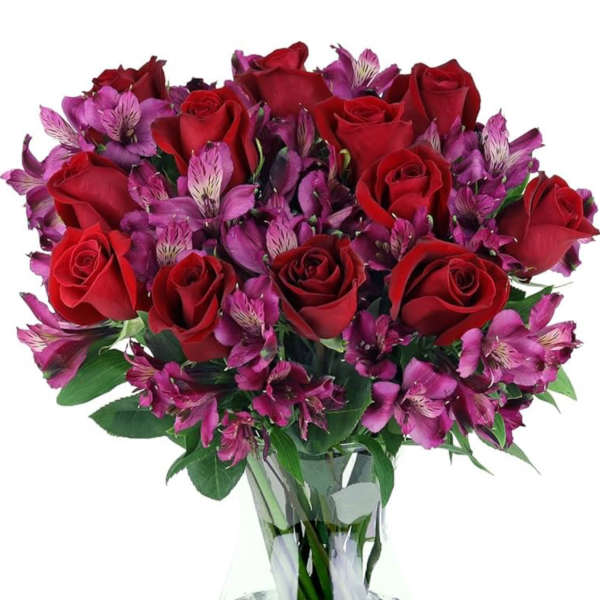 Bouquet of red roses and purple alstroemeria in a clear glass vase