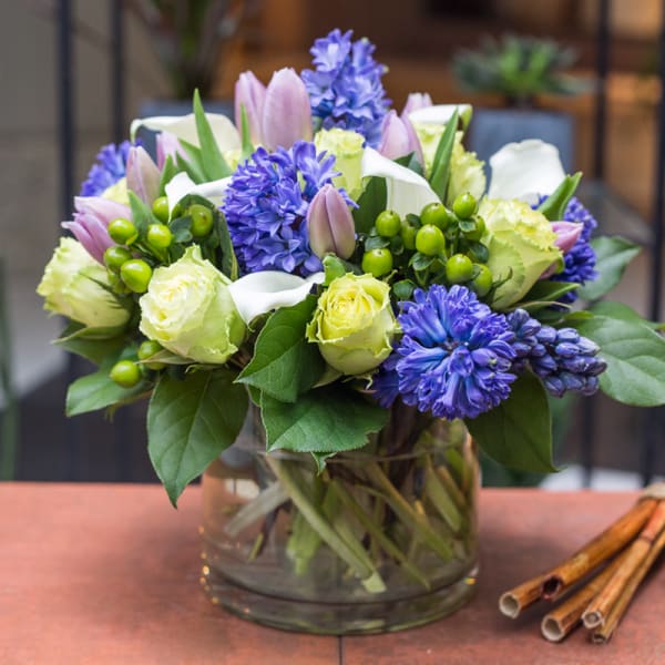 Bouquet of purple and pale yellow flowers in a glass vase