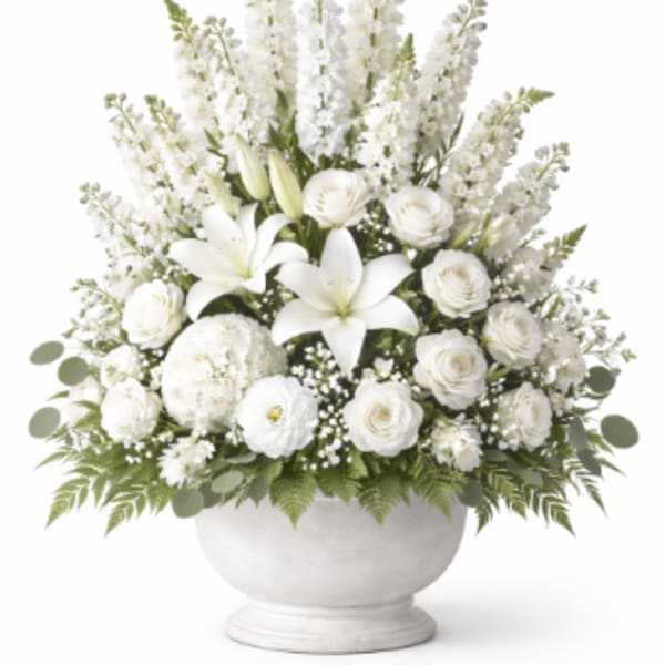 White floral arrangement in a round pedestal vase