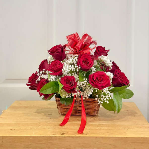 Basket of red roses with baby's breath and a red ribbon bow