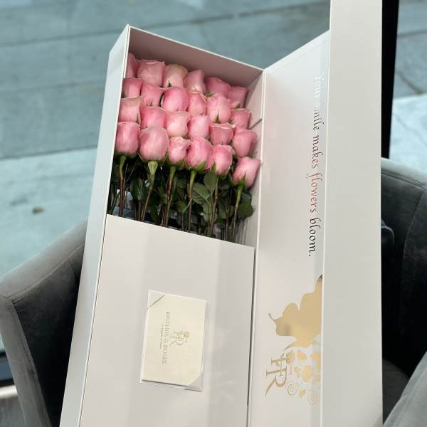 Boxed bouquet of pink roses with a card inside