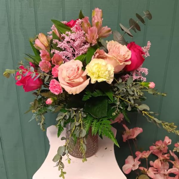 Bouquet of pink and peach roses in a textured vase