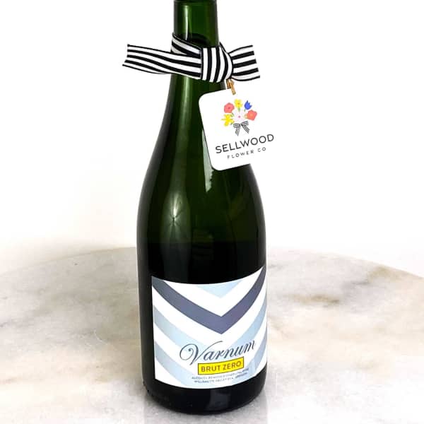 Bottle of sparkling wine with a striped ribbon and hanging tag