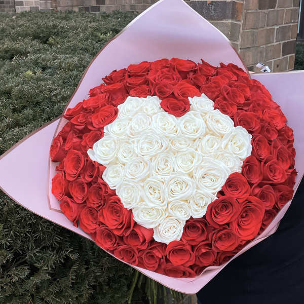 Large bouquet of red and white roses wrapped in pink paper