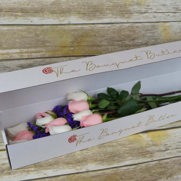 Pink and white roses in a long white gift box