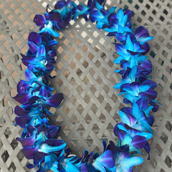 Blue and purple flower lei on a lattice table