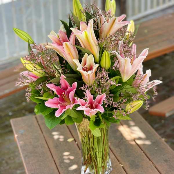 Pink and white lilies in a clear glass vase