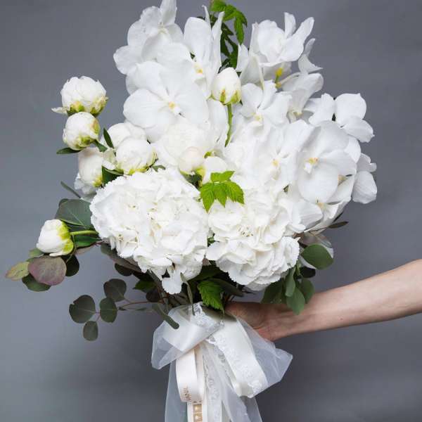 White floral bouquet with a satin and lace ribbon wrap