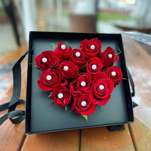 Heart-shaped box of red roses with pearl accents