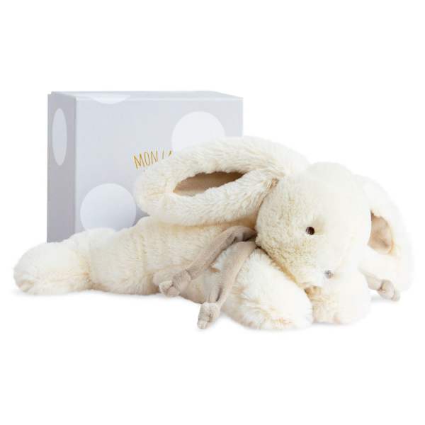 Plush cream-colored bunny toy with a gift box behind it