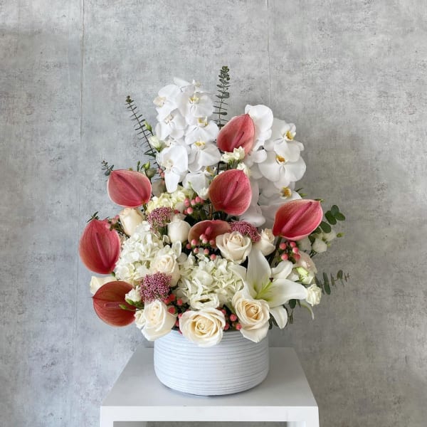 White and pink floral arrangement in a white vase